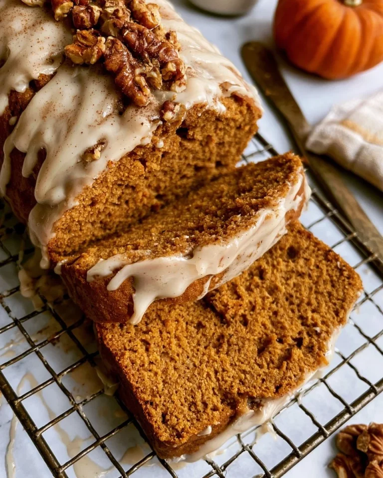 Slice of healthy pumpkin bread topped with maple glaze on a wooden surface