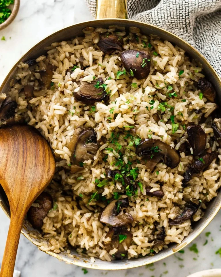 Bowl of creamy mushroom rice topped with fresh herbs